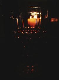 Close-up of lit candles in dark room