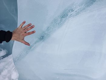 Cropped hand of person touching ice