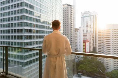 Rear view of man looking at city buildings