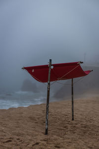 Lifeguard hut on beach against sky