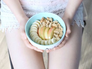 Midsection of woman holding breakfast in bowl