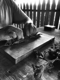 Close-up of man rolling on dry leaves on wooden board