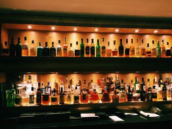 Liquor bottles arranged on shelf in bar