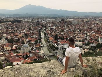 Read view of young man watching at panoramic view of town prizren in kosovo