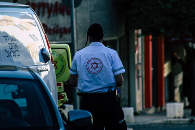 Rear view of man walking on street in city