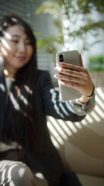 Midsection of man using mobile phone