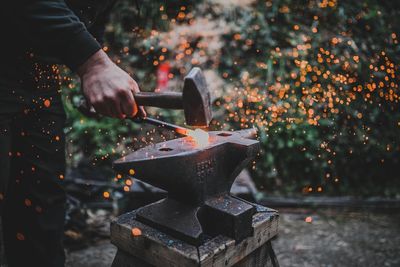 Midsection of man preparing food on barbecue grill