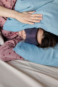 Portrait of woman lying on bed at home