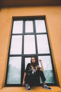 Portrait of woman sitting in window