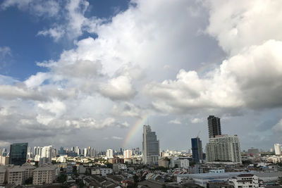 Buildings in city against cloudy sky