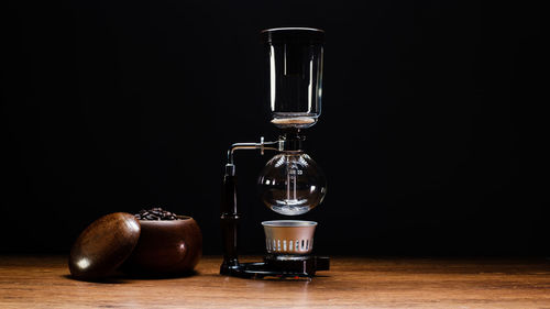 Close-up of wine glass on table against black background