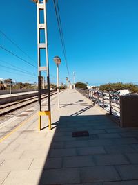 View of railroad station platform against blue sky