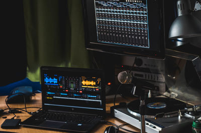 Close-up of laptop by turntable at recording studio