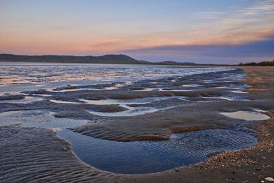 Scenic view of beach against sky during sunset