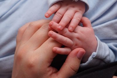 Close-up of mother and baby hands