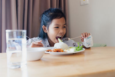 Portrait of girl sitting on table