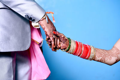 Midsection of couple holding hands