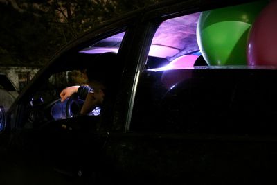 Midsection of man in illuminated car at night