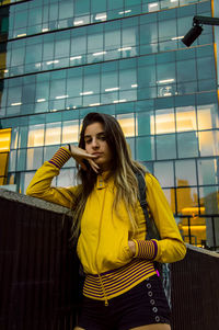 Beautiful young woman standing against built structure