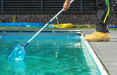 Low section of man swimming in pool