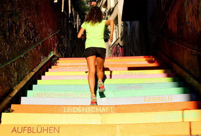 Low angle view of woman climbing steps in city