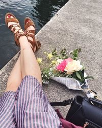 Low section of woman with pink flower on floor