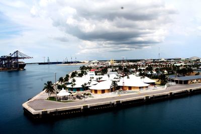 Boats in harbor against sky in city