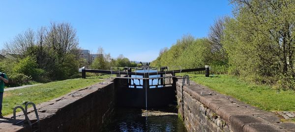 Scenic view of canal against clear blue sky