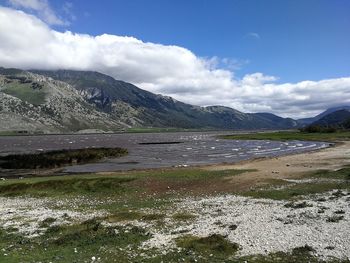 Scenic view of sea and mountains against sky