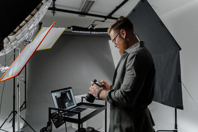 Midsection of businessman using laptop at office