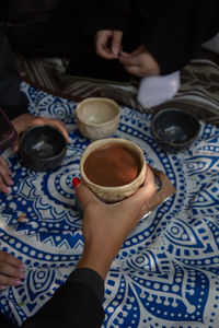 Cropped hand of woman holding coffee at home