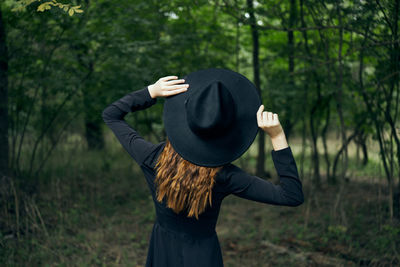 Full length of woman wearing hat standing on field