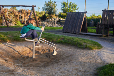 Bulldozer of a playground with a girl playing, with beautiful sunset colors