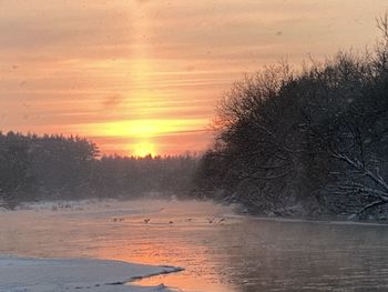 Scenic view of snow covered land during sunset