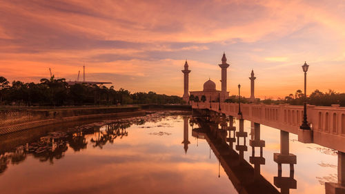 Reflection of building on water at sunset