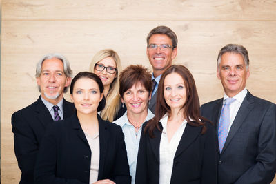 Portrait of friends standing against wall