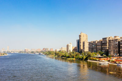 River by city against clear blue sky