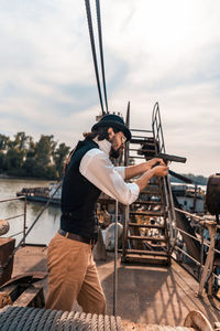 Man standing on boat against sky