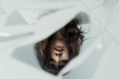 Reflection of woman in broken mirror on floor