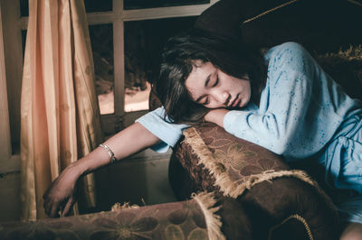 Tired woman relaxing on sofa at home