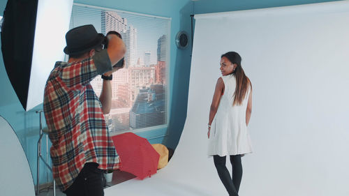 Young woman looking away while standing on mirror