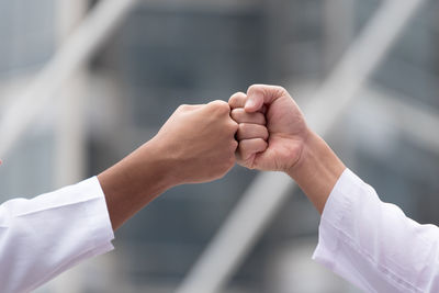 Cropped image of friends clenching fist