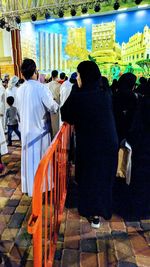 Rear view of people standing at temple