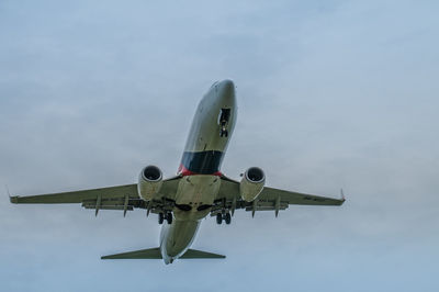 Low angle view of airplane flying against sky