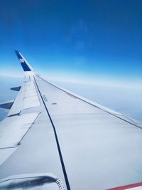 Close-up of airplane wing against clear blue sky
