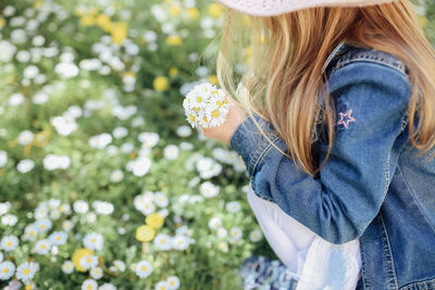 Midsection of woman holding flowering plant