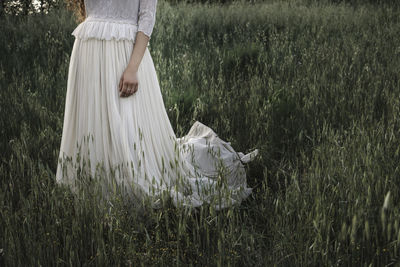 Low section of woman standing on field