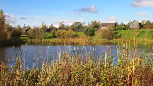 Scenic view of lake by building against sky