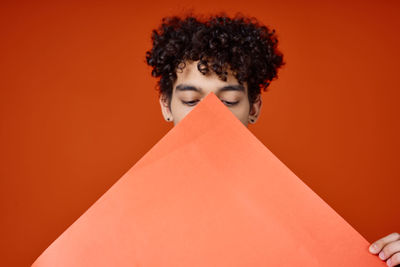 Portrait of man standing against red background