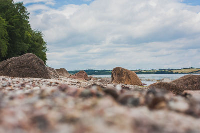 Surface level of rocks on beach against sky